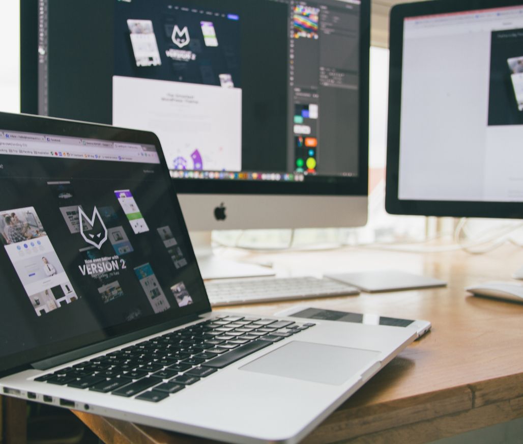 desk and screens set up to design websites